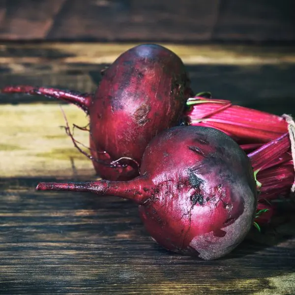 2 fresh beets on a brown wooden table