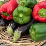 Aubergine with green and red peppers in a whicker basket