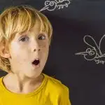 the-boy-is-bitten-by-mosquitoes-on-a-dark-background-on-the-blackboard-with-chalk-painted-mosquitoes-banner-long-format