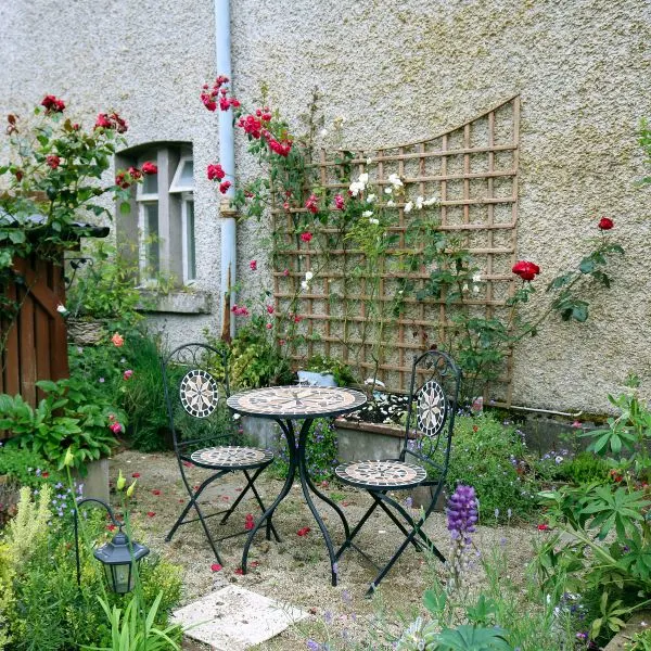 Small patio table and two chairs in a small garden